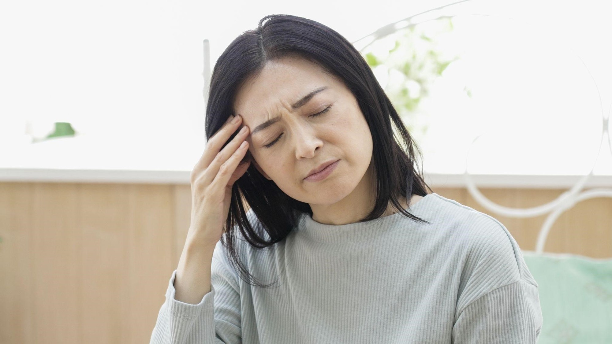 Người phụ nữ trung niên ôm đầu đau nhức